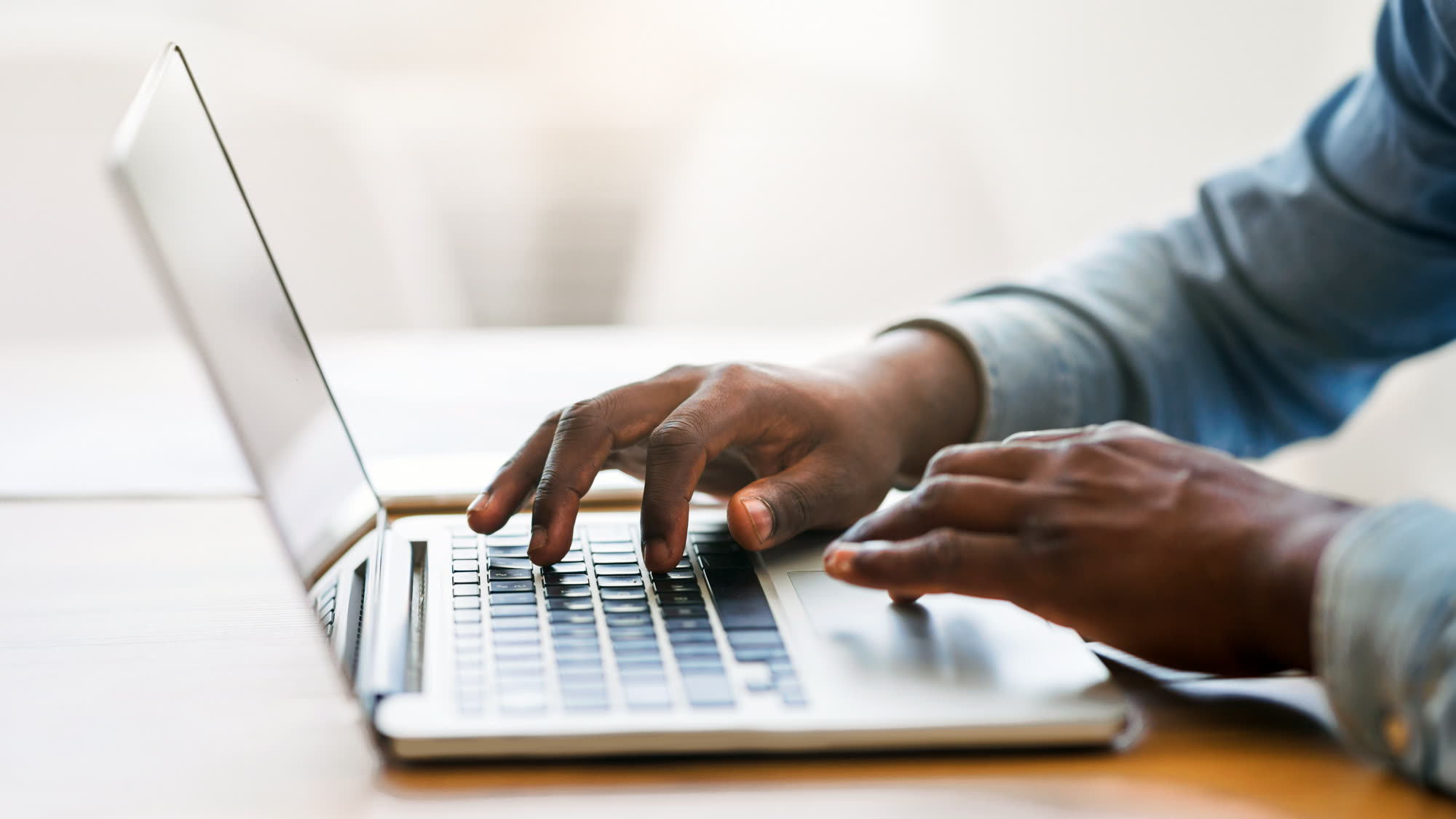 Hands of an African American businessman typing on a laptop keyboard