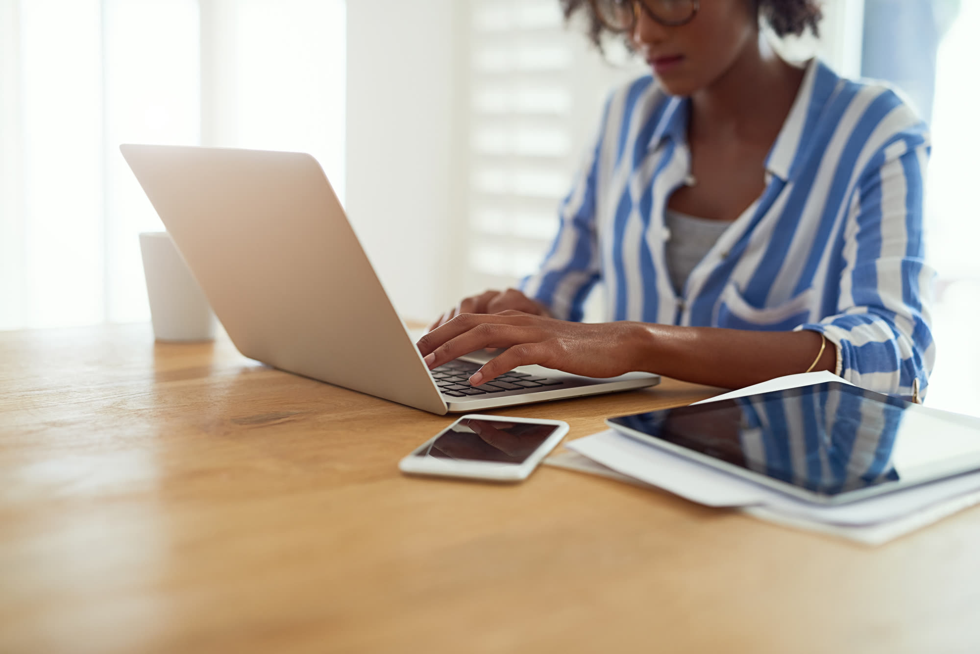African woman working on a laptop writing an email marketing campaign